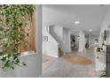 Bright foyer with tile floors, stairs, decorative plants, and sightlines to an adjacent dining area at 2926 Royal Fern Ln, Charlotte, NC 28215