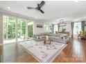 Bright living room featuring hardwood floors, modern ceiling fan, and an oversized gray sectional sofa at 3227 Cape Fox Ct, Denver, NC 28037