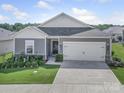 Single-story home featuring a two-car garage, and well-maintained lawn and landscaping at 3317 Black Cherry Dr, Monroe, NC 28110