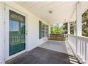Inviting covered front porch features a swing, railing, and a door with glass panels at 38367 Loblolly Ln, New London, NC 28127