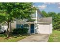 Inviting two-story home with an attached garage and well-manicured lawn at 7643 Monarch Birch Ln, Charlotte, NC 28215