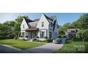 Gorgeous white brick home showcases lush landscaping, a private driveway, and a detached garage at 914 Edinburgh Ln, Charlotte, NC 28209