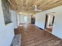 Spacious living room featuring wood-look floors, unfinished walls, and a ceiling fan at 1004 S Ridge Ave, Kannapolis, NC 28083