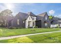 Beautiful home exterior with dark brick, light accents, professionally landscaped yard, and natural light at 10119 Laurier Ln, Huntersville, NC 28078