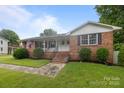 Charming brick home featuring a well-manicured lawn and inviting front porch with steps at 115 Fox Run Dr, Fort Mill, SC 29715