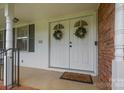 Elegant double front doors adorned with wreaths and a 'Welcome' mat, creating a warm entrance at 115 Fox Run Dr, Fort Mill, SC 29715
