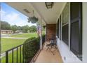 Inviting covered porch with cozy seating, fresh flowers, and an American flag on display at 115 Fox Run Dr, Fort Mill, SC 29715