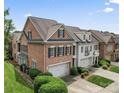 Aerial view of brick townhouses showing garages and manicured landscaping at 11724 Easthampton Cir, Charlotte, NC 28277