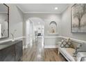 Elegant hallway with hardwood floors, detailed molding, and a decorative archway leading to the living area at 11724 Easthampton Cir, Charlotte, NC 28277