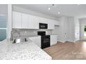 Modern kitchen with stainless steel appliances, granite countertops, and white cabinetry at 1225 Langston Ln, Salisbury, NC 28144