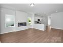 Open living space with a fireplace, hardwood floors, and a view of the modern kitchen at 1225 Langston Ln, Salisbury, NC 28144