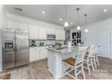 Well-lit kitchen boasts white cabinets, granite countertops, stainless steel appliances, and an eat-in island at 1248 Langston Ln, Salisbury, NC 28144