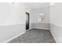 Bright hallway features neutral paint, carpet, and an exterior window for natural light at 14624 Via Sorrento Dr # 6206, Charlotte, NC 28277