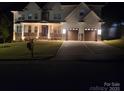 Exterior view of home at night with a beautifully lit front porch and well-manicured lawn at 15818 Sparrowridge Ct, Charlotte, NC 28278
