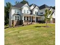 Charming two-story home with a welcoming front porch, beautiful stone accents, and a well-maintained lawn at 15818 Sparrowridge Ct, Charlotte, NC 28278