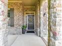 Inviting front entrance with stone archway and brick accents, showcasing a welcoming wreath on the door at 2005 Arbor Hills Dr, Indian Trail, NC 28079