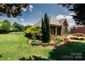 Landscaped backyard featuring lush green grass, mature trees and plantings, and a fence at 225 Northchase Dr, Concord, NC 28027