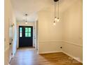 Inviting entryway featuring modern lighting, wood-look floors, and a stylish black front door at 3106 Faircroft Way, Monroe, NC 28110