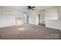 Open living room boasts carpet, neutral walls, fireplace, and a view into other rooms at 411 S Central Ave, Landis, NC 28088