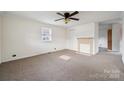 Spacious living room with carpet, neutral walls, a ceiling fan, and a decorative fireplace at 411 S Central Ave, Landis, NC 28088