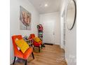 Warm entryway featuring wood floors, a decorative painting, and seating with colorful accents at 5580 Soft Shell Dr, Lancaster, SC 29720