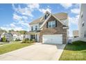 Two-story house with a brick and vinyl facade, a two-car garage, and a well-kept green lawn at 5580 Soft Shell Dr, Lancaster, SC 29720