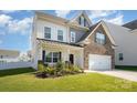Two-story home with a brick and vinyl facade, two-car garage, and a well-maintained green yard at 5580 Soft Shell Dr, Lancaster, SC 29720