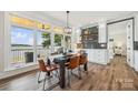 Stylish dining area featuring a modern light fixture, wooden floors, and lake views at 5985 Natoma Rd, Clover, SC 29710