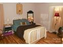 Cozy bedroom featuring hardwood floors, a comfortable bed and matching decor at 6148 Meadow Rose Ln, Charlotte, NC 28215