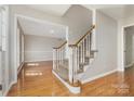 Inviting foyer features hardwood floors, a staircase with carpeted steps, and views into the adjacent living room at 6603 Brenock Ln, Charlotte, NC 28269