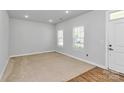 Cozy living area featuring neutral carpeting and fresh paint at 7079 Waterwheel Sw St, Concord, NC 28025