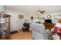 Cozy living room features laminate flooring, neutral green paint, and a ceiling fan at 816 Radio Rd, Statesville, NC 28677