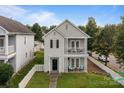 Two-story home with double balconies and a white picket fence enclosing the lush, green front lawn at 9704 Grier Springs Ln, Charlotte, NC 28213