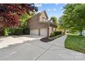 Large three-car garage with a spacious driveway and side yard surrounded by lush greenery at 10320 Lemington Dr, Mint Hill, NC 28227