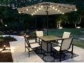 Cozy outdoor patio with table, chairs, umbrella, and ambient lighting at 104 Bunker Way, Mooresville, NC 28117