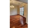 Elegant dining room showcasing hardwood floors, wainscoting, and a chandelier at 10607 Old Bridge Ln, Charlotte, NC 28269