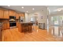 A spacious kitchen features an island with barstool seating, hardwood floors, and stainless steel appliances at 1103 Phar Lap Dr, Indian Trail, NC 28079