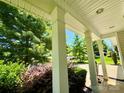Inviting front porch with classic columns and lush landscaping offering an intimate outdoor relaxation space at 11109 Pond Valley Ct, Charlotte, NC 28269