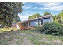 Exterior view of home with large front yard and damaged exterior at 112 Harmony Trl, Gastonia, NC 28056