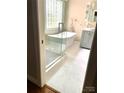Modern bathroom with glass enclosed shower and a standalone soaking tub and marble flooring at 1237 Saint Johns Ave, Matthews, NC 28104