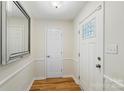 Bright foyer with a white door, trim, a mirror, and wood flooring offering a clean and inviting entrance at 1556 Stanley Lucia Rd, Mount Holly, NC 28120
