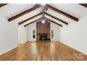Expansive living room showcasing a brick fireplace, exposed beams, and hardwood floors, offering rustic charm and modern appeal at 1556 Stanley Lucia Rd, Mount Holly, NC 28120