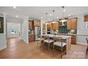Open-concept kitchen with wooden cabinets, a center island with seating, stainless steel appliances, and hardwood flooring at 2192 Millennium Dr # 91, Lancaster, SC 29720