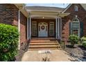 Inviting brick porch with white columns, wrought iron railings, and a decorative wreath at 2909 Arbor Knl, Concord, NC 28025