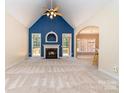 Open living room with vaulted ceiling, fireplace, and large windows with access to deck at 2909 Arbor Knl, Concord, NC 28025
