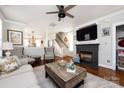 A relaxing living room area features a fireplace, flatscreen TV and an open view to other rooms at 298 Bridges Farm Rd, Mooresville, NC 28115