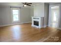 Bright living room with hardwood floors, a ceiling fan, and a decorative fireplace at 315 Second St, Stanley, NC 28164
