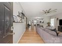Spacious living room features an open floor plan, hardwood floors, and a ceiling fan at 389 Whispering Hills Dr, Locust, NC 28097