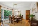 Elegant dining room featuring a large window, stylish chandelier, and classic wooden furniture at 5008 Saddle Horn Trl, Weddington, NC 28104