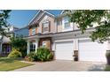 Beautiful home exterior with a two-car garage and stone accents at 6313 Woodland Commons Dr, Charlotte, NC 28269